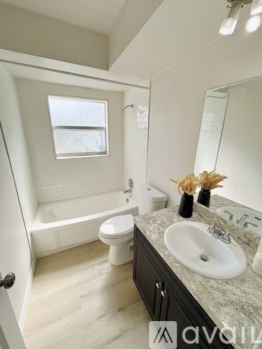 A bathroom with a toilet, sink, and bathtub.