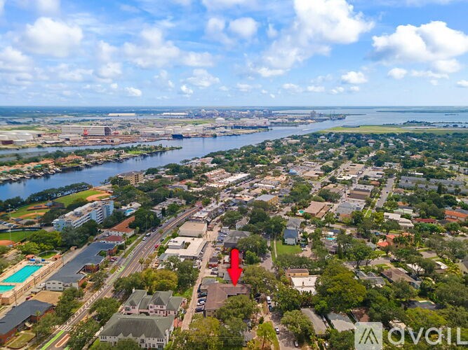 A red arrow points to a building in a city with a river running through it.