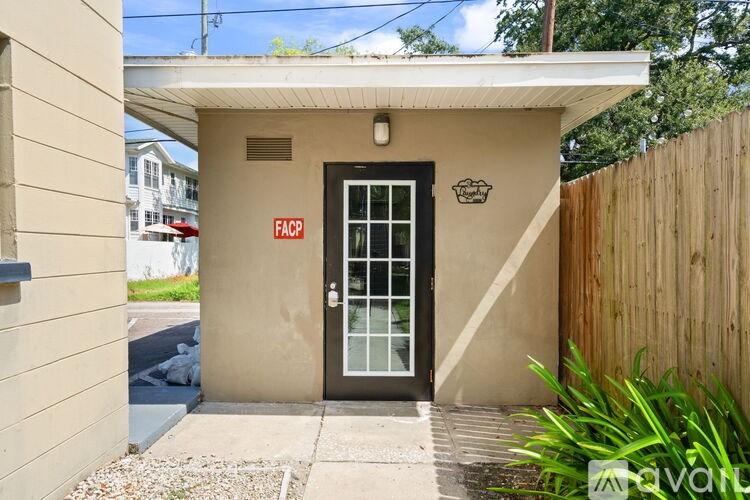 A small building with a black door and a sign that reads "FACP" on the wall.