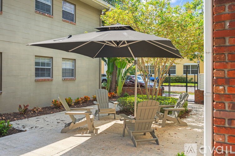 A patio with a table, chairs and an umbrella.