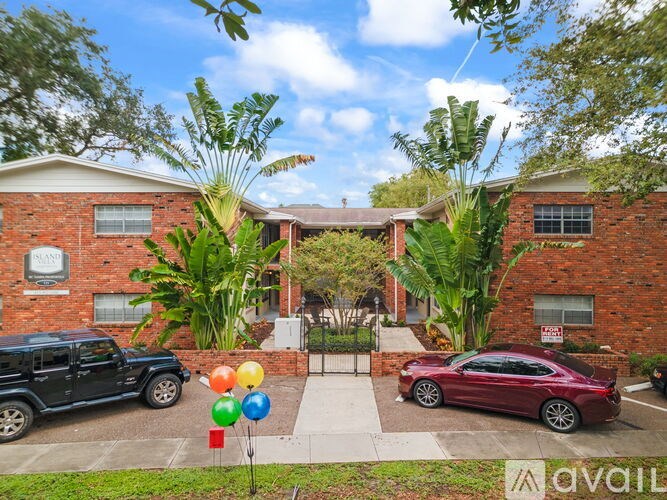 A house with a red car parked in front and a black jeep parked in the driveway.