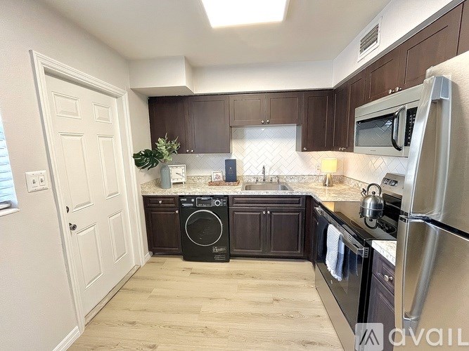 A kitchen with dark brown cabinets and stainless steel appliances.