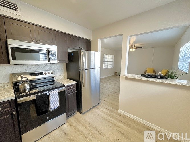 A kitchen with a stove, oven, microwave, and refrigerator.