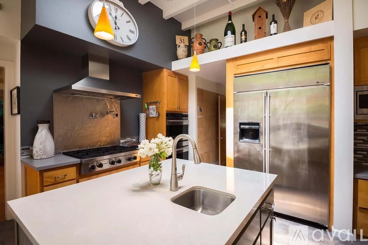 A kitchen with a stainless steel refrigerator and a white countertop.
