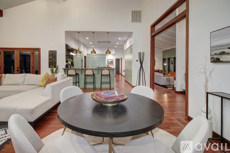 A modern dining room with a round table and white chairs.