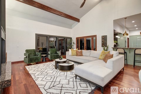 A living room with a white couch and a patterned rug.