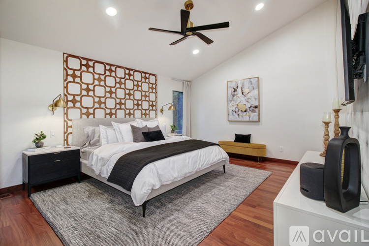 A bedroom with a large bed and a ceiling fan.