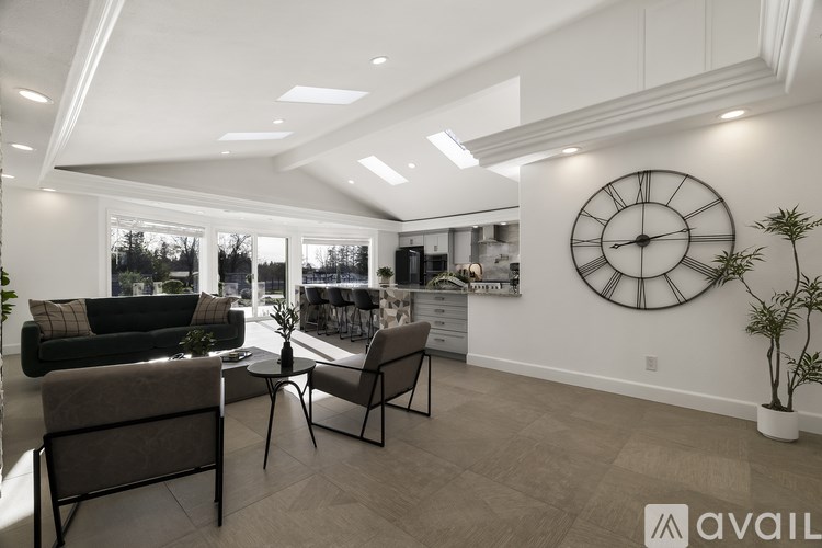 A living room with a large clock on the wall and a couch.