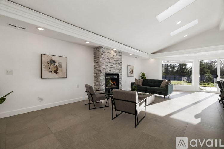 A modern living room with a fireplace and a large window.