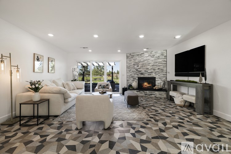 A modern living room with a stone fireplace and a large TV.