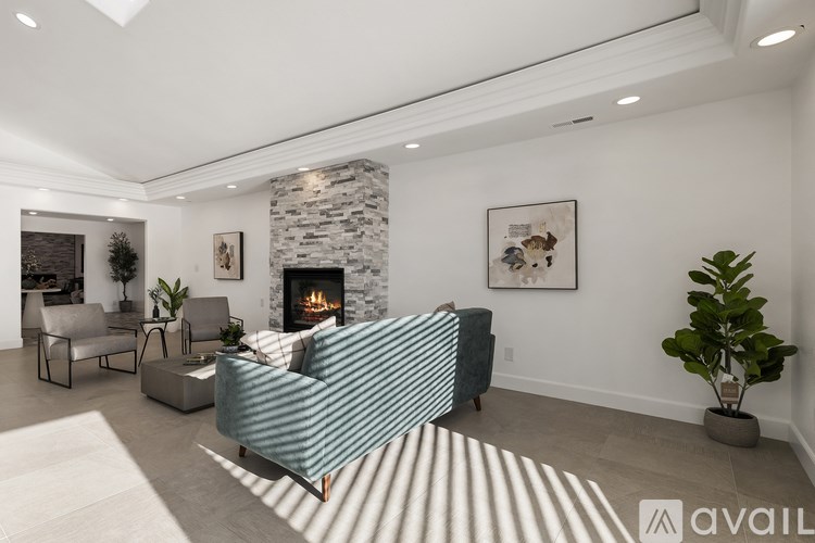 A living room with a fireplace and a striped couch.