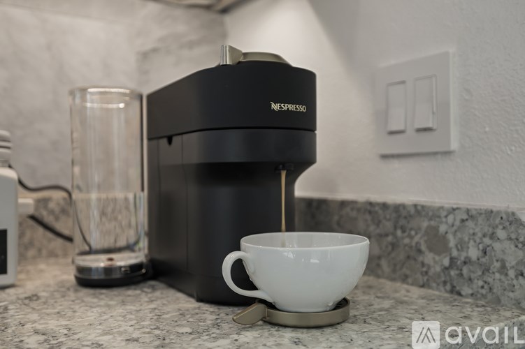A Nespresso coffee maker dispensing coffee into a cup.