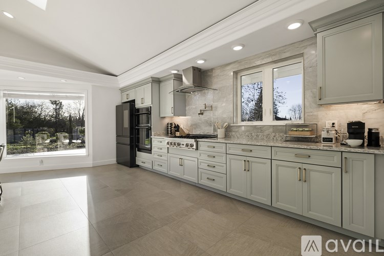 A modern kitchen with a large island and a refrigerator.