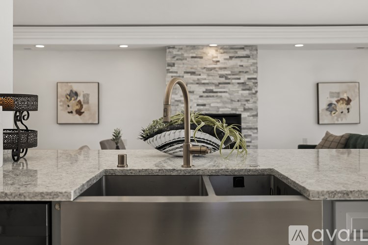 A modern kitchen with a marble countertop and a stone backsplash.