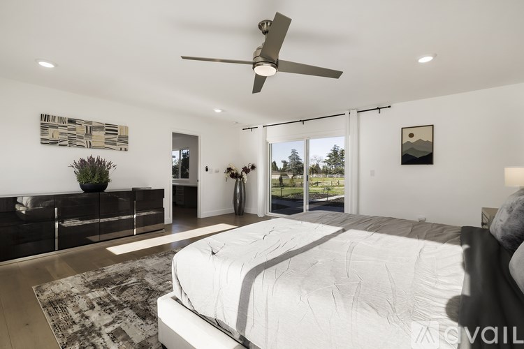 A bedroom with a large bed and a ceiling fan.