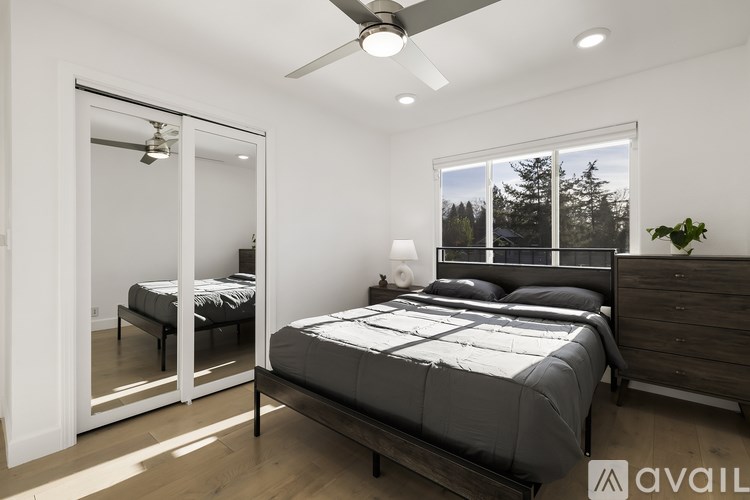 A bedroom with a large bed and a sliding glass door leading to a balcony.