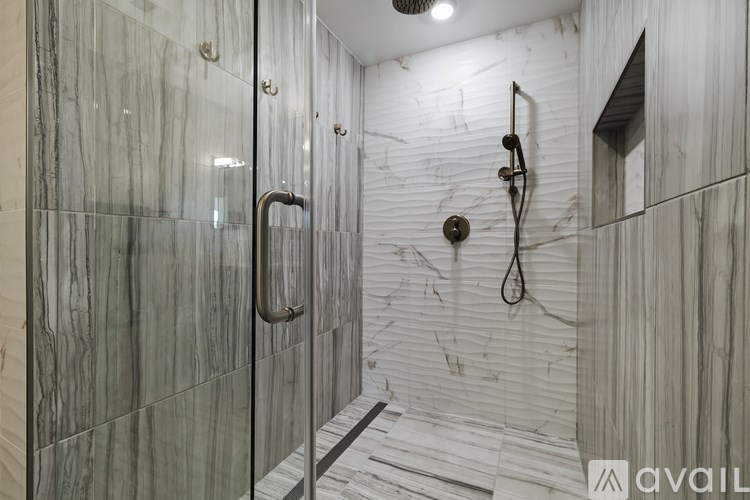 A bathroom with a walk-in shower and a glass door.