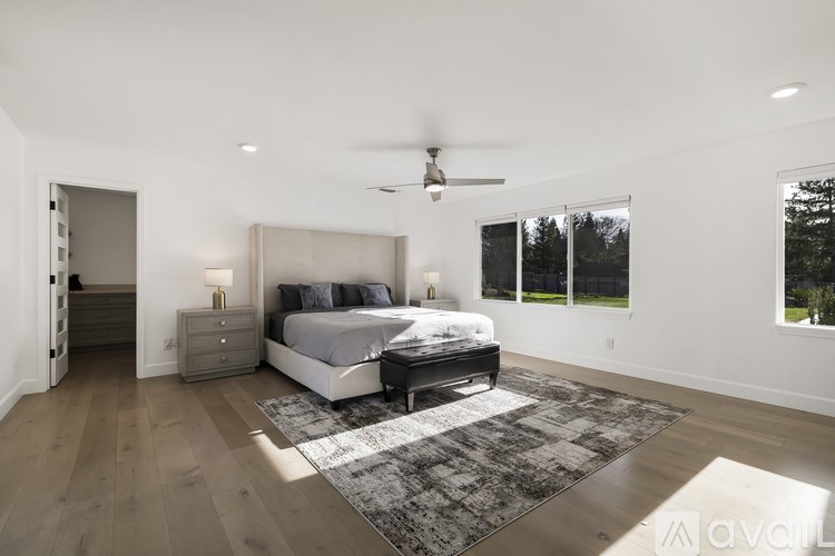 A bedroom with a large bed, a dresser, and a ceiling fan.