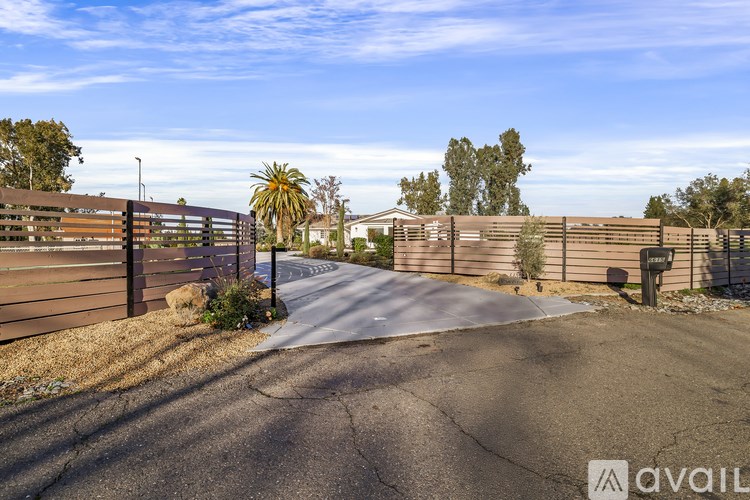A gated driveway with a sign that says "available" in the foreground.