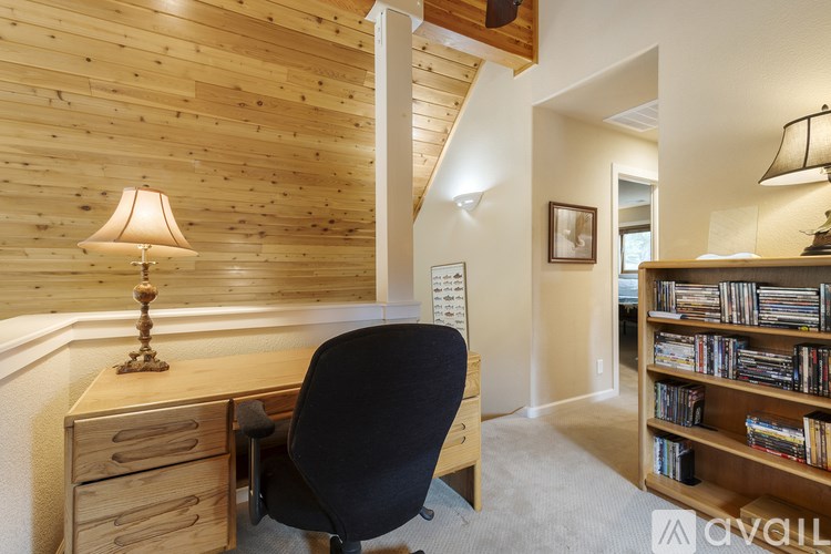 A room with a desk, chair, and bookshelf.