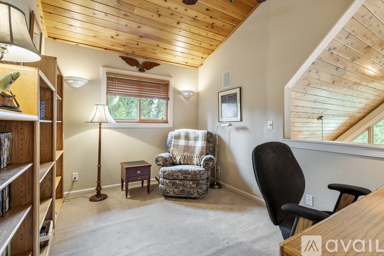 A living room with a chair, a couch, and a bookshelf.