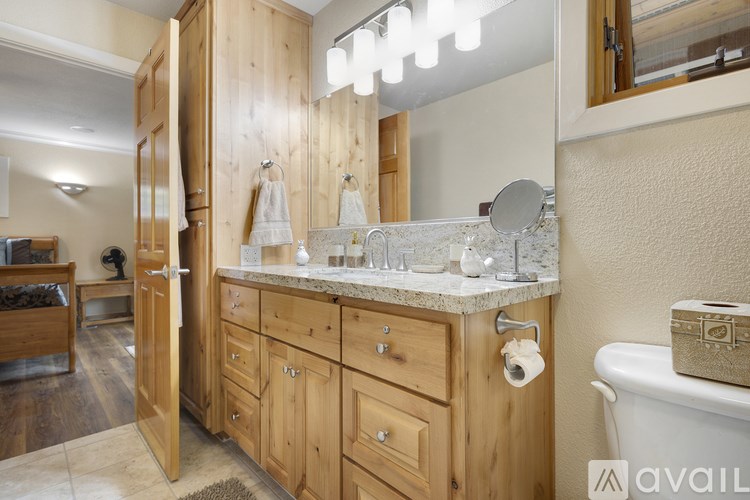 A bathroom with a wooden vanity and a white tub.