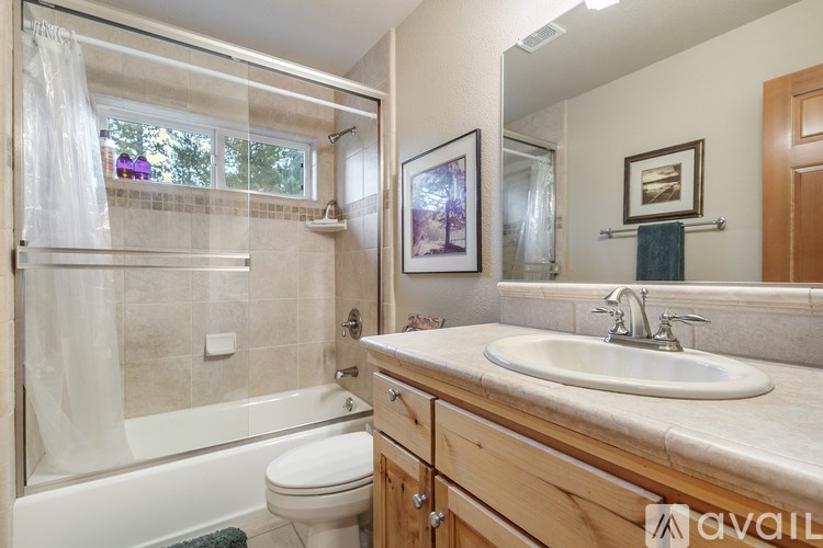 A bathroom with a white toilet, a bathtub with a shower curtain, a sink, and a mirror.