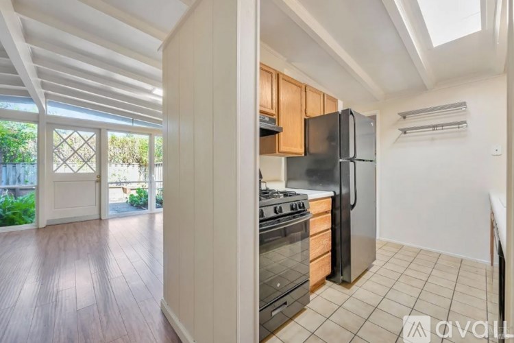 A kitchen with wooden cabinets and a black refrigerator.