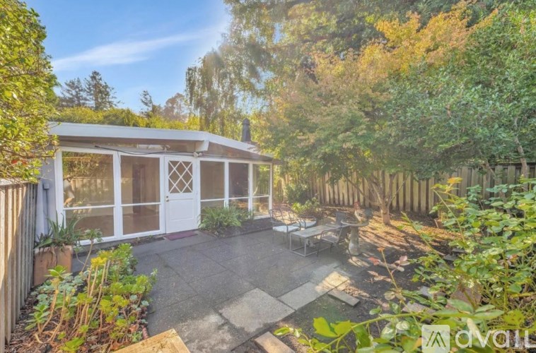 A backyard with a patio and a small house.