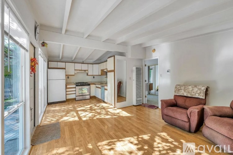 A living room with a brown sofa and a wooden floor.