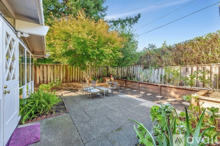 A backyard with a patio and a white door.