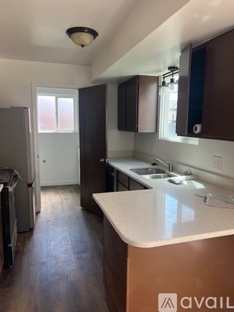 A kitchen with a white counter top and brown cabinets.