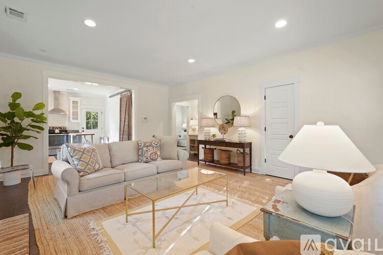 A well-lit living room with a grey sofa, a coffee table, and a large floor lamp.