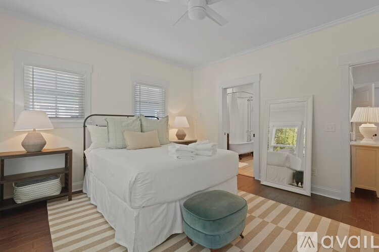 A bedroom with a large bed and a striped rug.