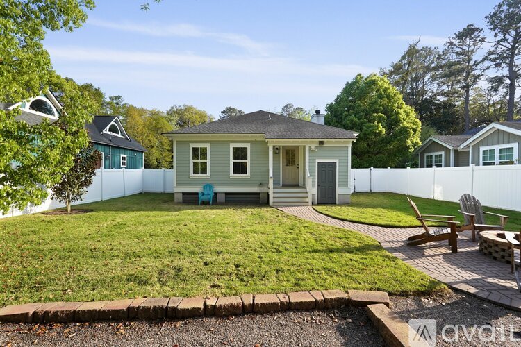 A house with a blue chair sits in a grassy backyard.