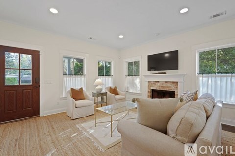 A living room with a white couch and a fireplace.
