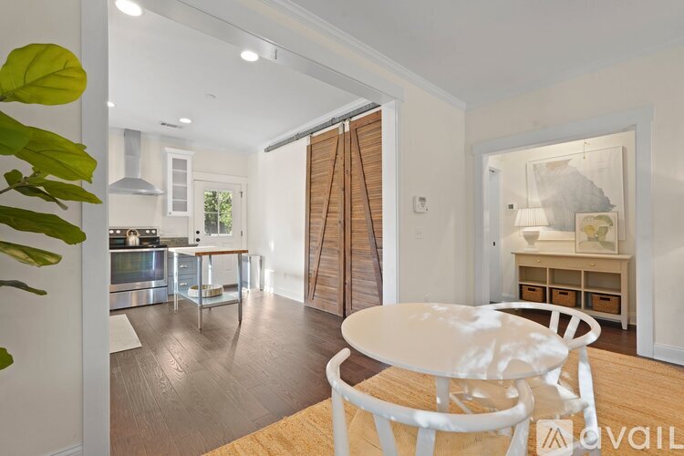 A modern kitchen with a dining table and chairs in the foreground.