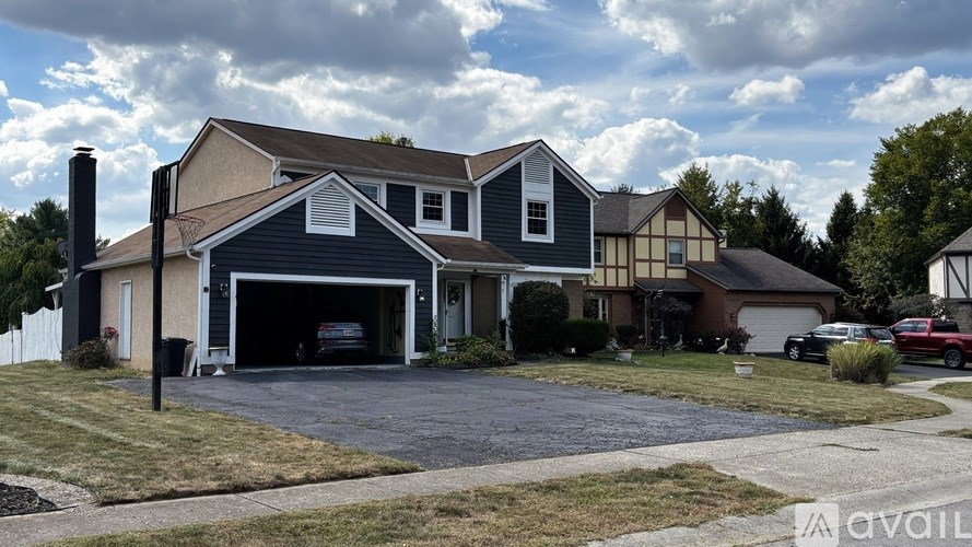A house with a garage and a driveway in front of it.