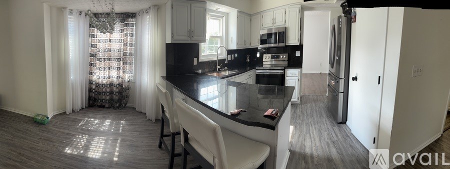 A kitchen with a black countertop and white cabinets.