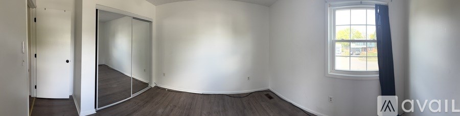 A room with a window and a door leading to another room.