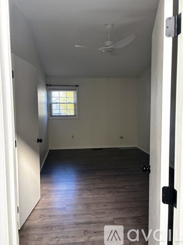 A room with a ceiling fan and a window.