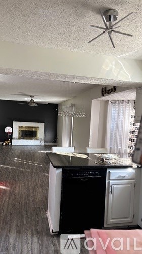 A kitchen with a black oven and a fan on the ceiling.