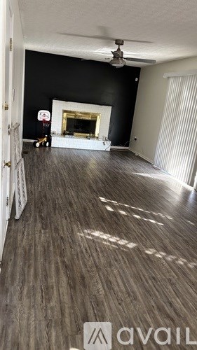 A room with a fireplace and a fan.