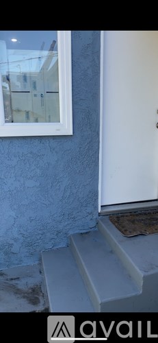 A white door is on the right side of a blue wall.