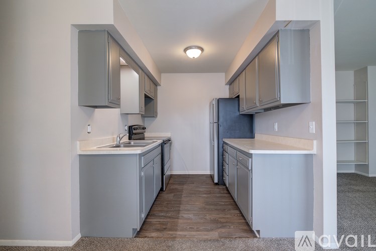 A kitchen with white cabinets and a wooden floor.