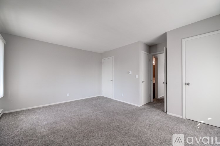A spacious room with a carpeted floor and white walls.