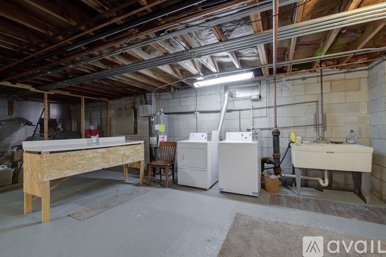 A room with a wooden table, a washing machine, and a dryer.