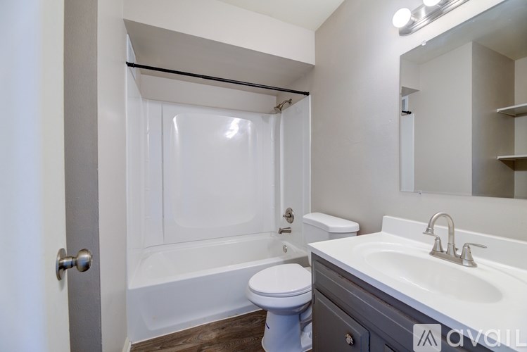 A white bathroom with a toilet, sink, and bathtub.
