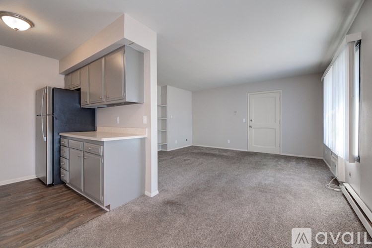 A kitchen area with a refrigerator, cabinets, and a countertop.