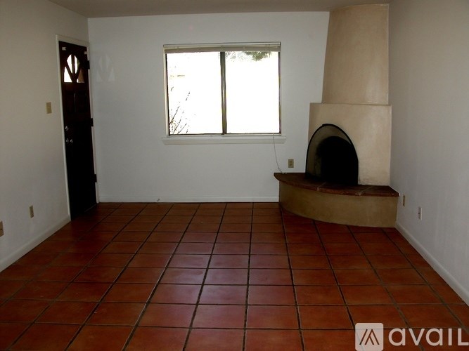 A room with a red tile floor and a wood-burning stove.